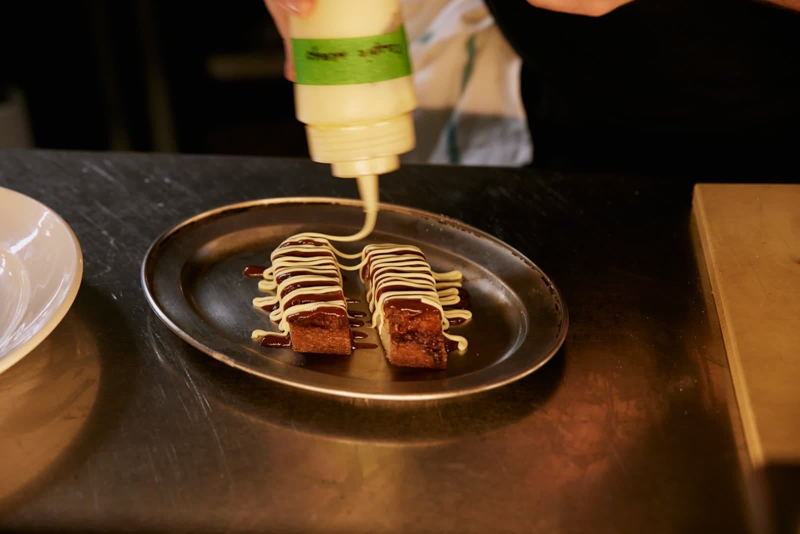 A dish being finished at the pass